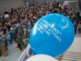 Blue balloon with Parkinson's motto on it in front of crowds of people at the Moveable Feast in Norwich